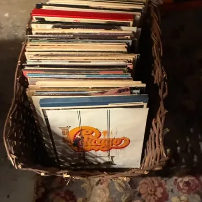 Collection of vintage vinyl LP records, including Chicago IX, stored in a rustic woven twig basket.