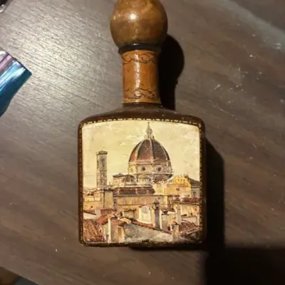 Vintage Italian leather-wrapped decanter bottle featuring an illustration of the Florence Cathedral, showing some wear to the leather and...