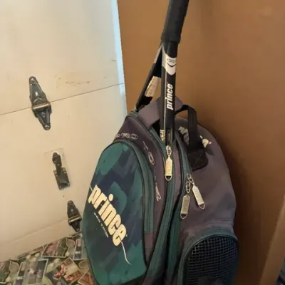 Vintage Prince Pro Tour tennis backpack in teal, grey, and black, shown holding a Prince tennis racket.