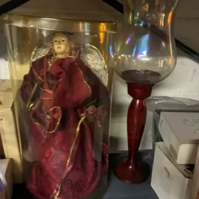 Vintage Christmas angel tree topper in original cylindrical plastic packaging, shown alongside a wooden hurricane candle holder with an...