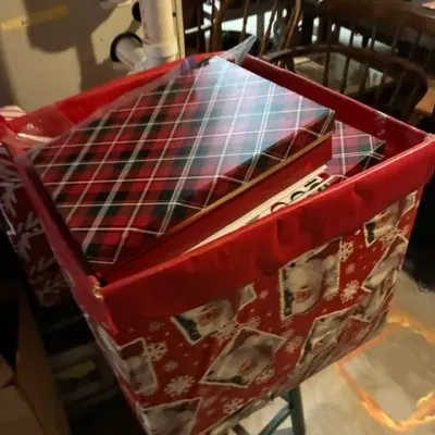 Assorted Christmas storage boxes, including a red Santa-themed bin and plaid gift boxes.
