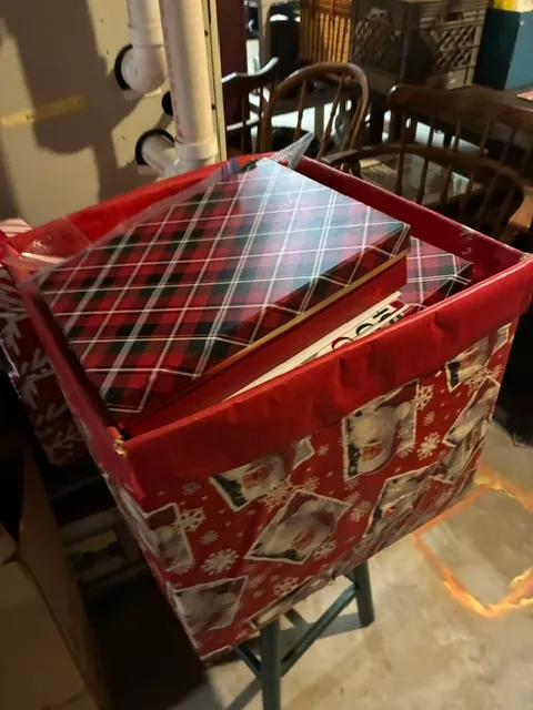 Assorted Christmas storage boxes, including a red Santa-themed bin and plaid gift boxes.