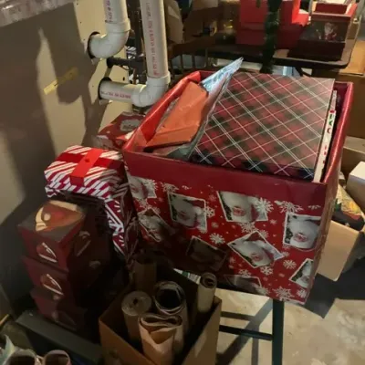Assortment of Christmas gift boxes, wrapping paper rolls, and holiday storage containers.
