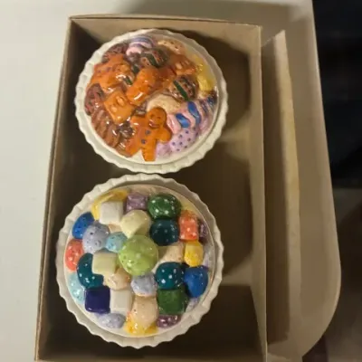 Pair of vintage ceramic tart-shaped trinket boxes with lids decorated to look like gingerbread cookies and colorful candies, presented in...
