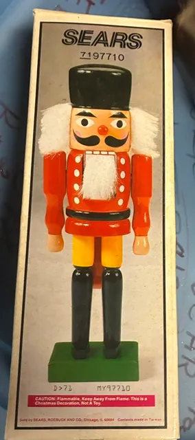Vintage Sears wooden soldier nutcracker in its original box, featuring a classic red, yellow, and black painted design with white faux...