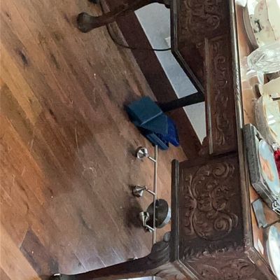 Ornate antique wooden desk featuring intricate hand-carved scrollwork details and classic cabriole legs with ball-and-claw feet.