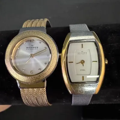 Two vintage Skagen Denmark women's wristwatches, featuring one round gold-tone model with a mesh band and one tonneau-shaped steel...