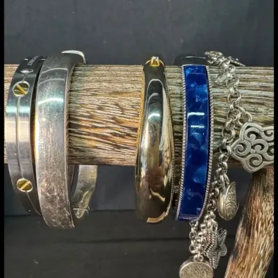 Assortment of fashion bracelets, including a silver-tone screw-motif bangle, a polished gold-tone hinged bangle, a blue enamel cuff, and...