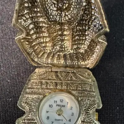 Vintage Pedre quartz pocket watch featuring an ornate, gold-tone Egyptian pharaoh sarcophagus case that opens to reveal the watch face.