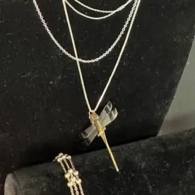 Sterling silver multi-strand necklace featuring a dragonfly pendant with gold-tone accents, displayed alongside a matching three-strand...
