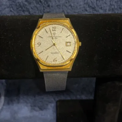 Vintage Jules Jurgensen quartz watch featuring a gold-tone octagonal bezel, textured silver dial with date window, and a stainless steel...