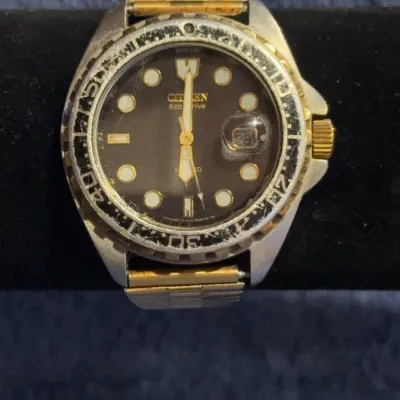 Citizen Eco-Drive WR 200 diver's watch with a black dial, gold-tone accents, and a heavily worn rotating bezel.