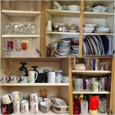 Assorted kitchenware and glassware, including ceramic mugs, plates, bowls, and drinking glasses, organized on wooden cabinet shelves.