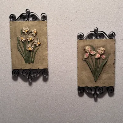 Pair of vintage Syroco-style floral wall plaques featuring relief-carved daffodils and irises on textured faux-stone backgrounds,...