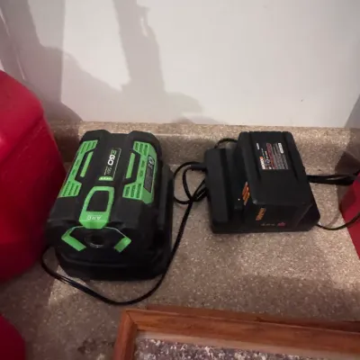 EGO Power+ 56V ARC Lithium battery on its charger alongside a Worx 40V battery and charger, both in gently used condition and...