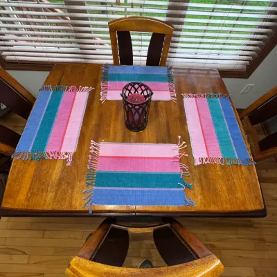 Wooden dining table and chairs set, featuring a square wooden table with four matching high-back chairs, decorated with colorful striped...