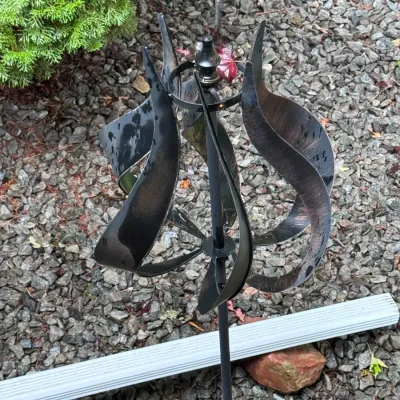 Stanwood Wind Sculptures dual-swivel kinetic copper wind spinner, featuring a vertical design with curved metal blades and a dark bronze...