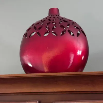 Contemporary metallic red ceramic vase featuring a bulbous silhouette and decorative openwork lattice cutouts around the upper shoulder.