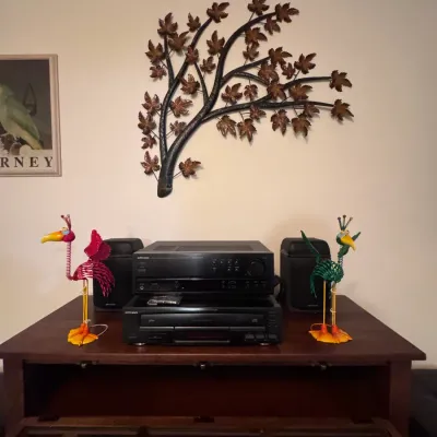 Optimus stereo receiver and CD changer system with matching speakers, flanked by whimsical metal bird figurines, displayed on a wooden...