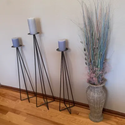 Home Decor: Trio of modern black metal tripod floor candle holders with lavender pillar candles, paired with a tall woven wicker floor...