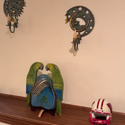 Home decor collection featuring a pair of celestial sun and moon metal wall sconces, a hand-painted wooden parrot wind spinner souvenir...