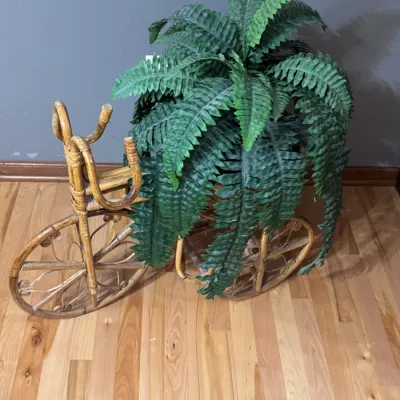 Vintage wicker and rattan tricycle plant stand, featuring a woven basket holding a faux fern plant, in the category of home decor and...