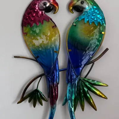 Regal Art & Gift tropical parrot metal and glass wall decor, featuring a pair of colorful macaws perched on branches with a vibrant,...
