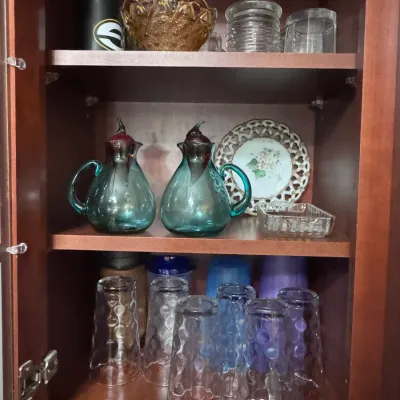 Vintage Blenko Glass hand-blown teal decanters with purple stoppers, made in the USA, displayed alongside a collection of glassware and...