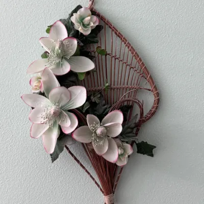 Vintage wicker wall pocket hanging basket, featuring a woven fan-shaped backing adorned with faux white and pink-tipped magnolias and...