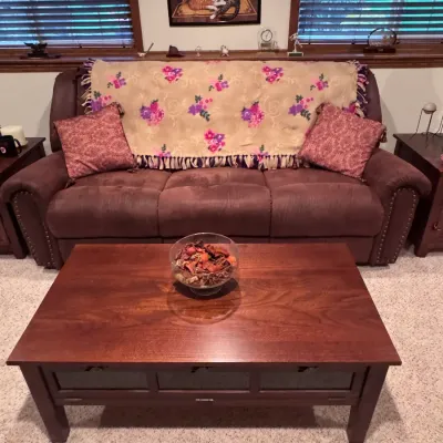 Living Room Furniture Set: A brown microfiber reclining sofa with nailhead trim, paired with a matching cherry-finished wooden coffee...