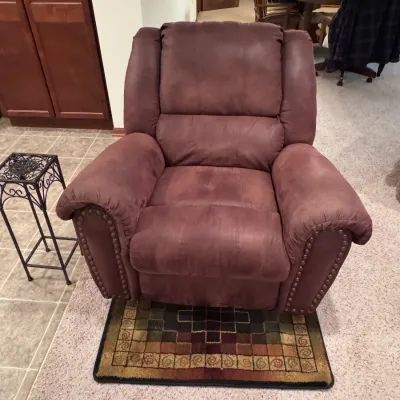 Plush brown microfiber recliner armchair featuring nailhead trim details along the rolled arms, shown in gently used condition.