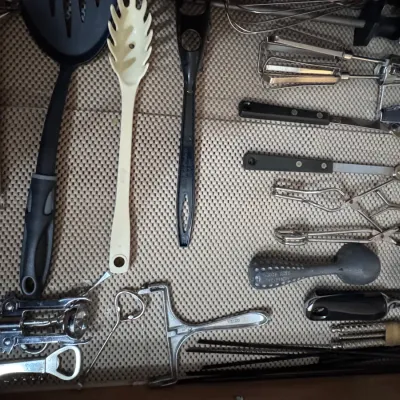 Assorted kitchen utensils and gadgets, including a vintage Scoop-Rite ice cream scoop made in the USA, a cheese slicer, corkscrews,...