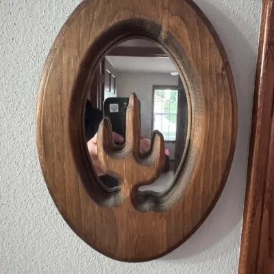 Vintage handmade wooden oval wall mirror featuring a carved saguaro cactus silhouette in the center, showcasing a rustic Southwestern style.