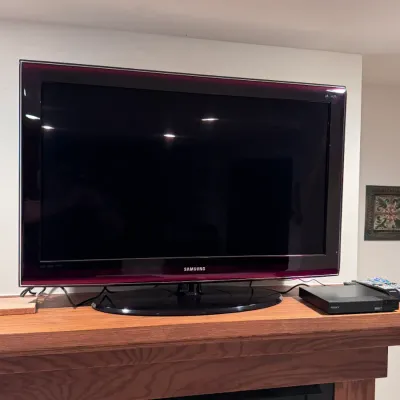 Samsung flat-screen television featuring a distinctive Touch of Color burgundy bezel, made in Mexico, paired with a Sony Blu-ray player...