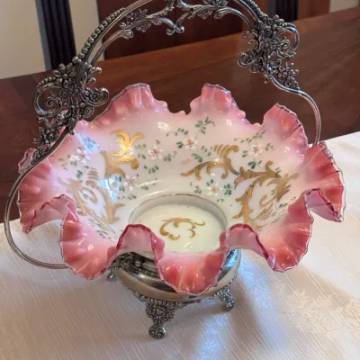 Victorian-era cased glass bride's basket, likely Fenton or Mt. Washington, featuring a ruffled pink and white opalescent bowl with...