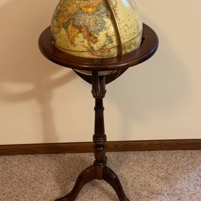 Vintage Replogle floor globe on a turned mahogany tripod stand, featuring a brass meridian ring and detailed political cartography...