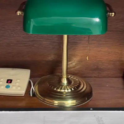 Vintage Emeralite-style banker's desk lamp featuring a classic green glass shade, polished brass base and stem, and a traditional...