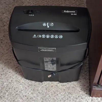 Fellowes W-6C cross-cut paper shredder in black, featuring a 6-sheet capacity, integrated wastebasket with a viewing window, and safety...