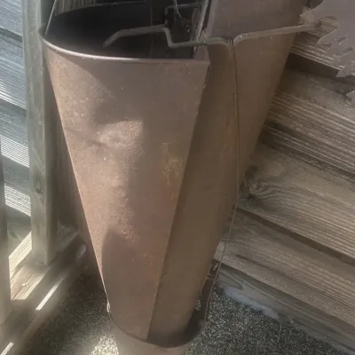Vintage metal hand planter tool with a rusted finish and wooden handle grip.
