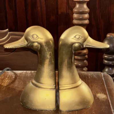 Pair of vintage solid brass duck head bookends with a warm, aged patina.