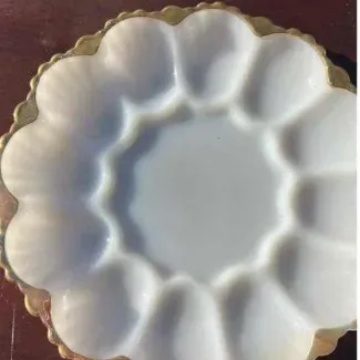 Vintage white milk glass deviled egg platter featuring a scalloped gold-gilt rim and twelve molded egg wells.