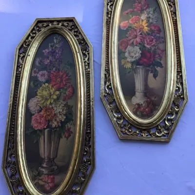 Pair of vintage mid-century floral still life prints in ornate, elongated octagonal gold-toned plastic frames.