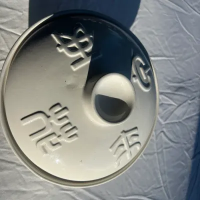 Vintage white ceramic lidded casserole dish featuring embossed Chinese characters on the lid.