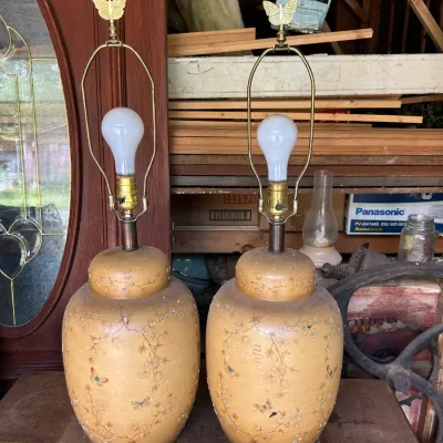 Pair of vintage ginger jar table lamps featuring a hand-painted floral and butterfly motif on a textured ochre background, topped with...