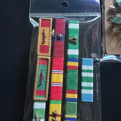 Assorted military service ribbon bars, including Vietnam Service and Republic of Vietnam Campaign ribbons, packaged in a clear plastic...