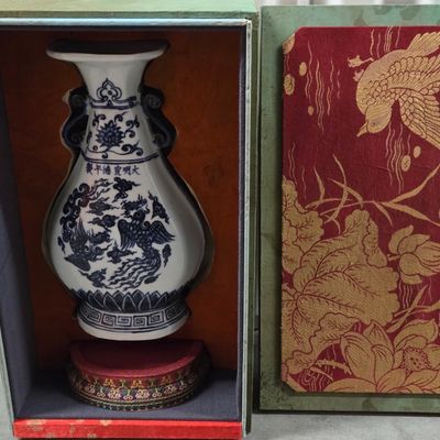 Chinese blue and white porcelain vase with dragon and phoenix motifs, presented in a fitted fabric-lined box with a decorative lid and...