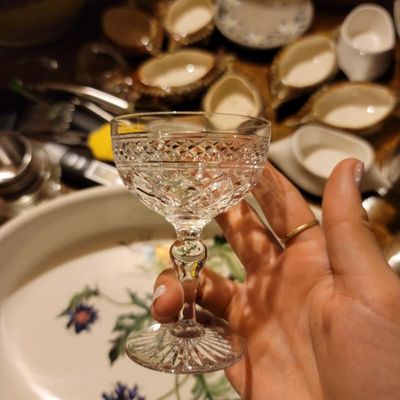 Vintage cut crystal cordial glass featuring a diamond pattern bowl, faceted stem, and starburst base.