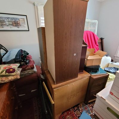 Lexington Furniture wooden chest of drawers and hutch top, shown stacked in a crowded room with various household items.
