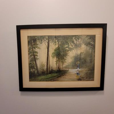 Framed watercolor painting depicting a figure with an umbrella walking along a misty forest path, presented in a simple black frame with...