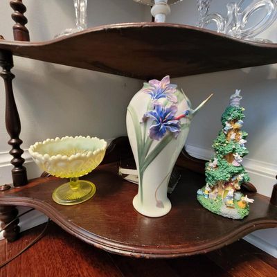 Franz Porcelain iris and hummingbird vase, flanked by a yellow vaseline glass pedestal dish and a whimsical Easter bunny tree figurine on...